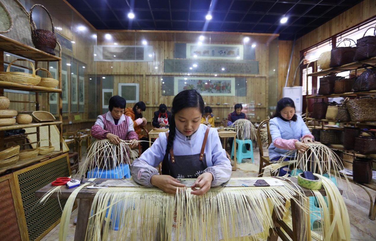 在贵州省赤水市大同镇民族村,几名妇女在赤水竹编传承人杨昌芹(前)